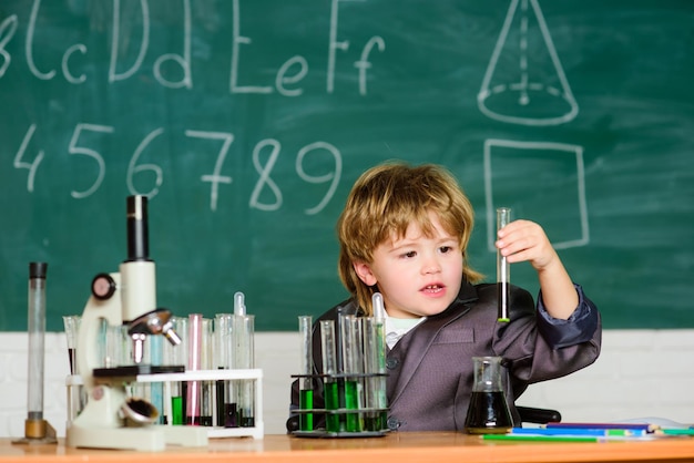 Esperimenti scientifici con microscopio in laboratorio Scuola di biologia bambino scienziato che studia scienze ragazzino a lezione Ritorno a scuola Il ragazzino sta facendo esperimenti scientifici Pronto per l'esame finale