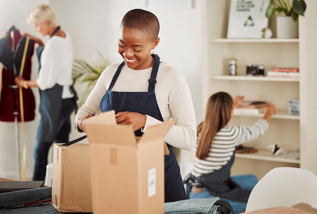 Esperto di abbigliamento soddisfatto del servizio del prodotto e dell'imballaggio Studio di moda o fabbrica per persone creative e qualificate Stilista e team di sarta ricevono la consegna di scatole con materiali di esportazione