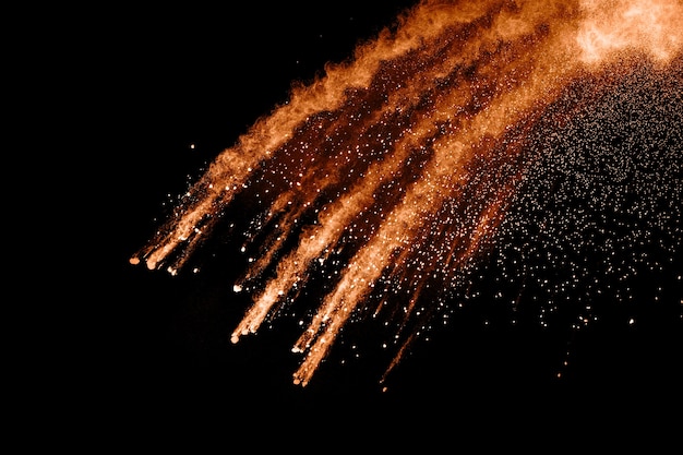 esplosione astratta di polvere arancione su sfondo nero.