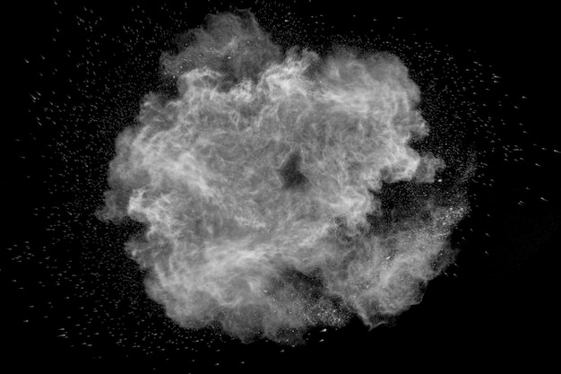 Esplosione di movimento congelato di polvere bianca su sfondo nero.