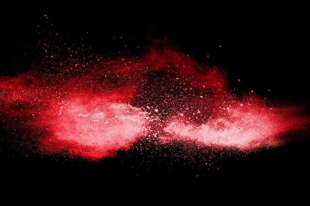 Esplosione di polvere di colore rosso su sfondo nero. Moto movimento di particelle di polvere rossa che schizza.