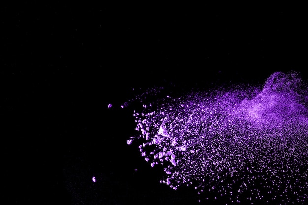 Esplosione di polvere di colore viola su sfondo nero.