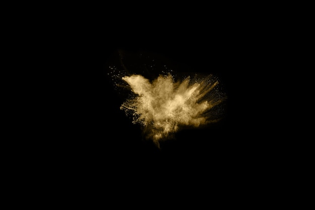 Esplosione di polvere dorata su sfondo nero. Blocca il movimento.