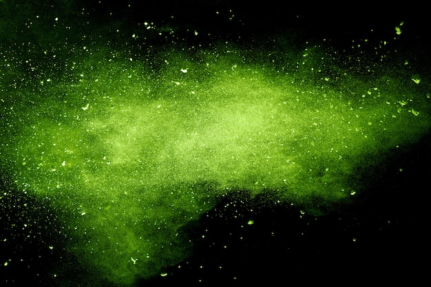 Esplosione di polvere verde su sfondo nero. Spruzzata di particelle di polvere verde.