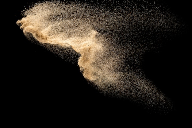 Esplosione di sabbia di fiume a secco. Spruzzata di sabbia di colore marrone su sfondo nero.