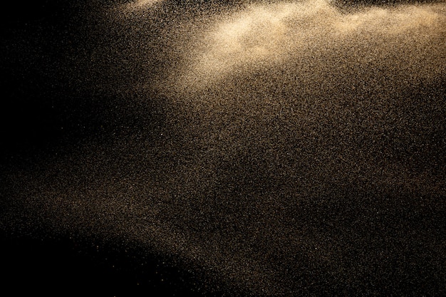Esplosione di sabbia dorata su sfondo nero