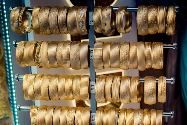 Esposizione del negozio di dozzine di falsi braccialetti d'oro