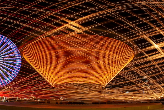 Esposizione lunga astratta del parco di divertimenti alla notte.