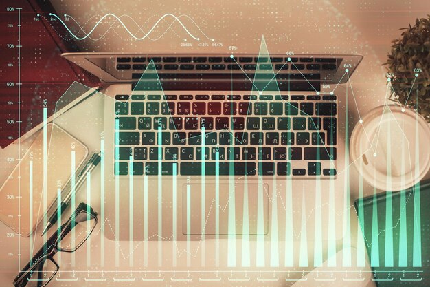 Esposizione multipla del grafico finanziario su sfondo di tabella con computer Concetto di ricerca Vista superiore