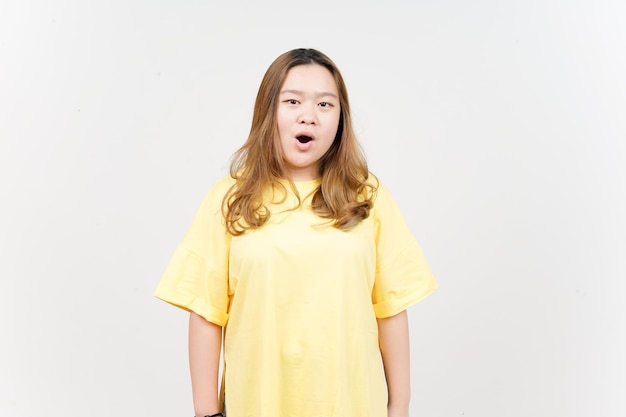 Espressione del viso WOW della bella donna asiatica che indossa una maglietta gialla isolata su sfondo bianco