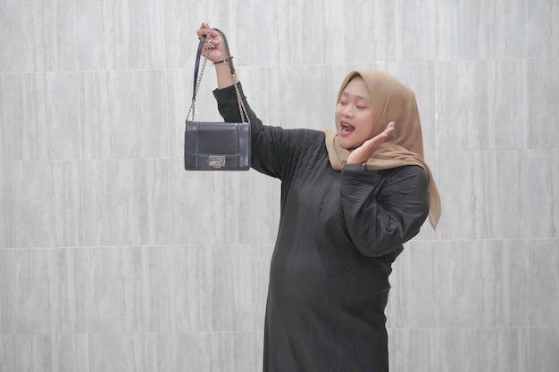 Espressione di una donna indonesiana asiatica che indossa un hijab marrone e abiti neri