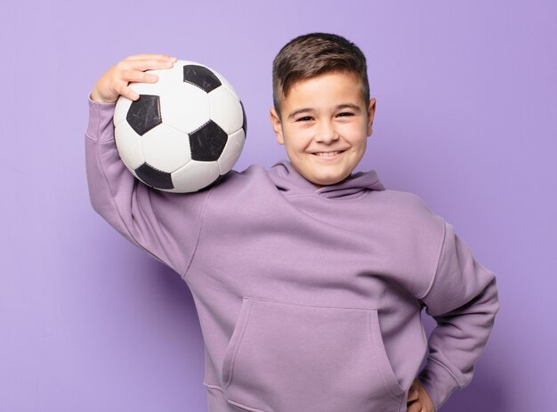 Espressione felice del ragazzino e che tiene un pallone da calcio