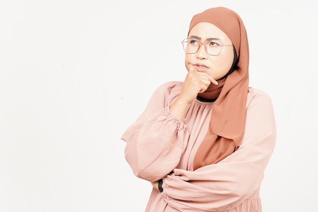 Espressione pensierosa e curiosa della bella donna asiatica che indossa l'hijab isolato su sfondo bianco
