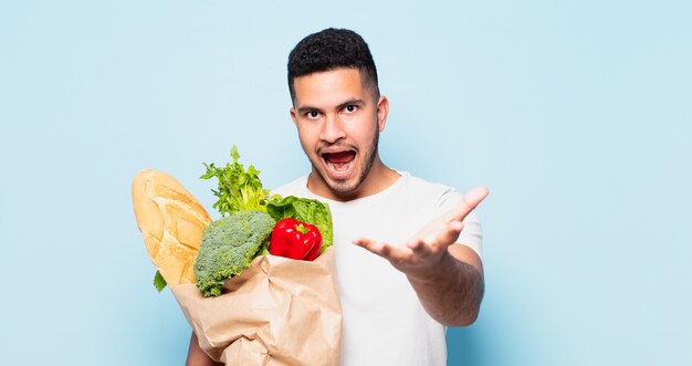 Espressione sorpresa del giovane uomo ispanico. concetto di acquisto di verdure