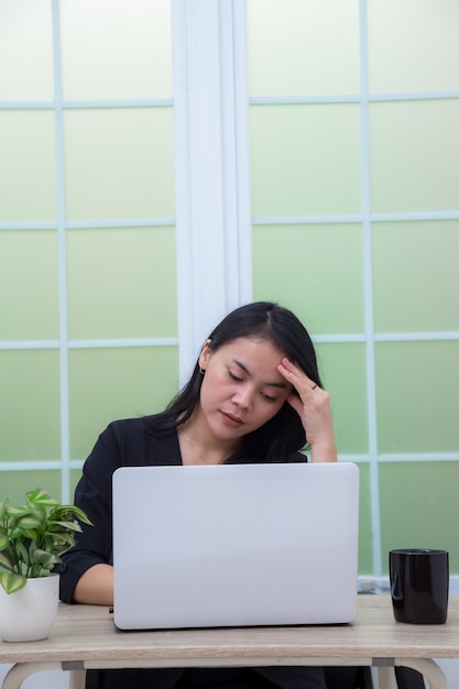 Espressione stanca della donna di affari con le mani sulla fronte