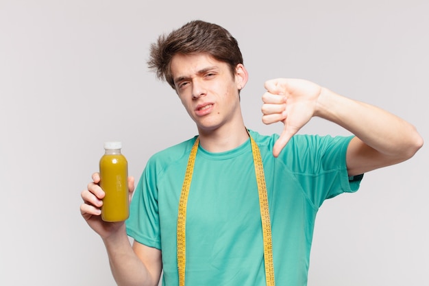 Espressione triste dell'uomo del giovane adolescente e che tiene un soothy. concetto di dieta