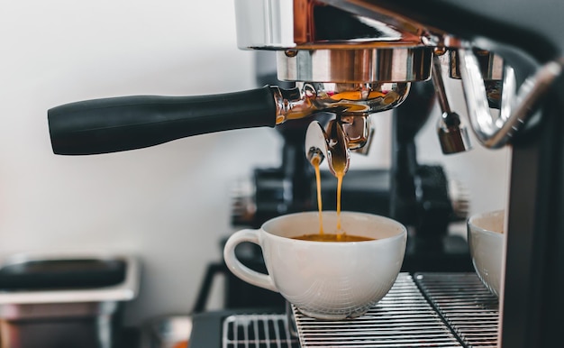 Espresso che versa dalla macchina per il caffè al bar