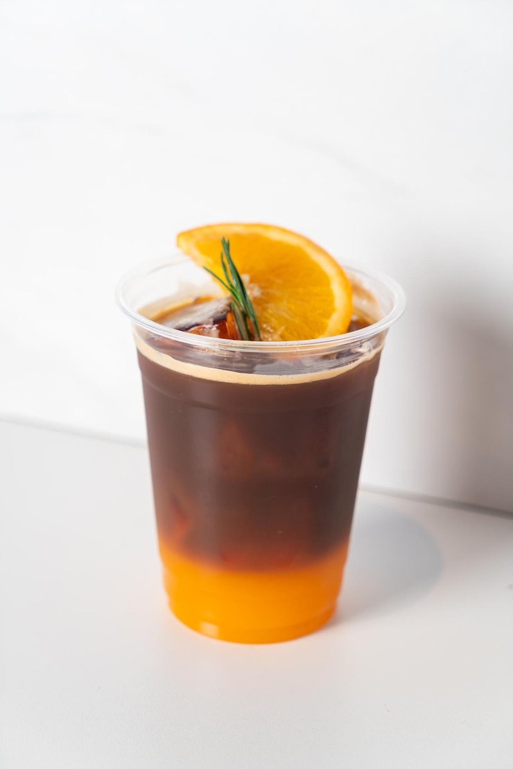 Foto espresso con succo d'arancia in vetro