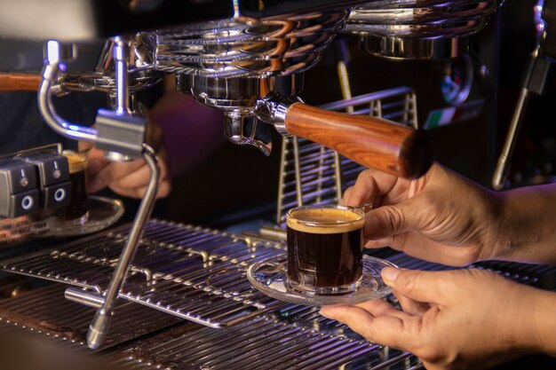 Espresso in preparazione dalla macchina per il caffè, macchina per il caffè che fa caffè da vicino.