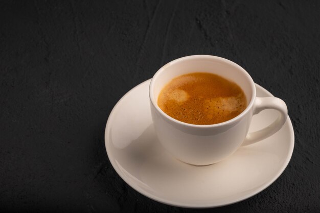 Espresso in tazza bianca su sfondo scuro