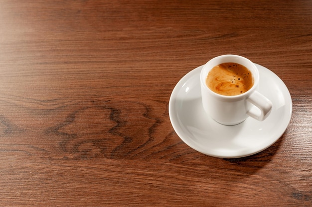 Espresso in un bicchiere corto su fondo di legno