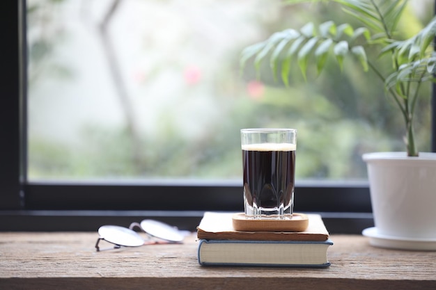 Espresso in una tazza di vetro e un piccolo vaso per piante di palma di bambù e bicchieri