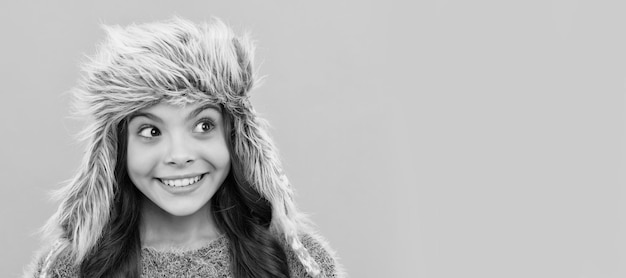 Esprimere emozione positiva moda invernale bambino felice con capelli ricci in cappello paraorecchie Faccia da bambino