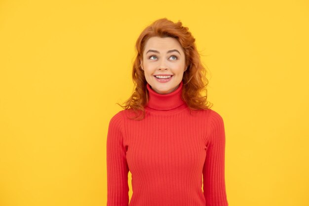 Esprimere emozioni positive signora allegra con capelli ricci bellezza e moda modello di moda femminile aspetto grazioso di giovane ragazza donna dai capelli rossi donna rossa felice guardando in alto su sfondo giallo