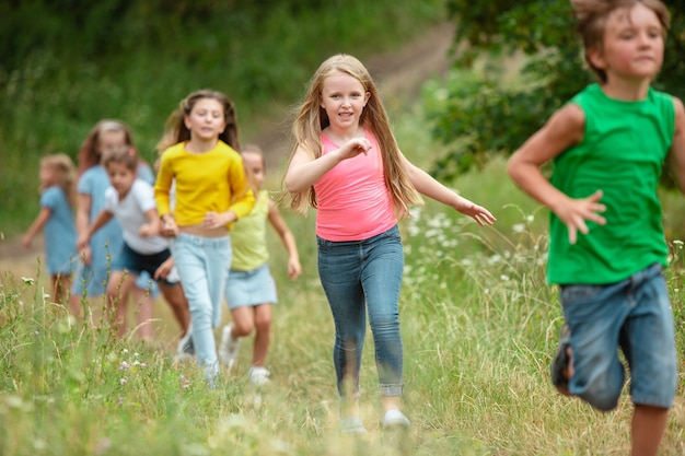 Estate. Bambini, bambini che corrono sulla foresta verde.