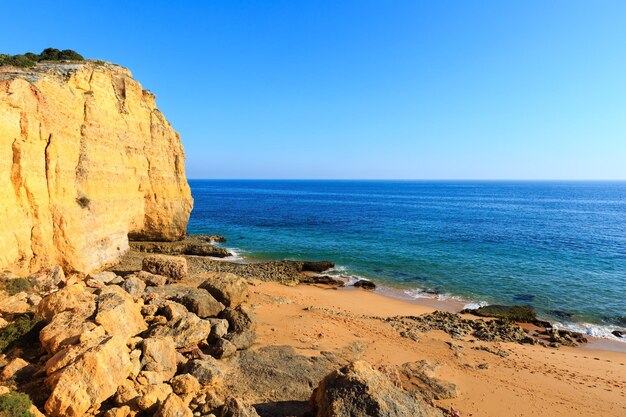 Estate costa rocciosa atlantica vista con spiaggia sabbiosa Praia dos Caneiros (Lagoa, Algarve, Portogallo).