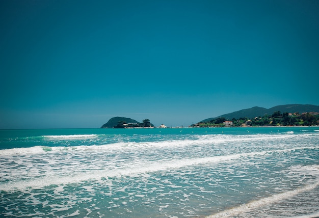 Estate della spiaggia con le nuvole e il cielo blu