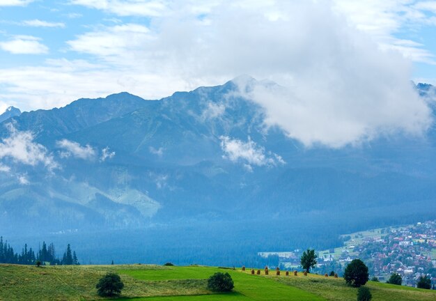 Estate nebbiosa periferia del villaggio di montagna con la gamma dei Tatra (Gliczarow Gorny, Polonia)