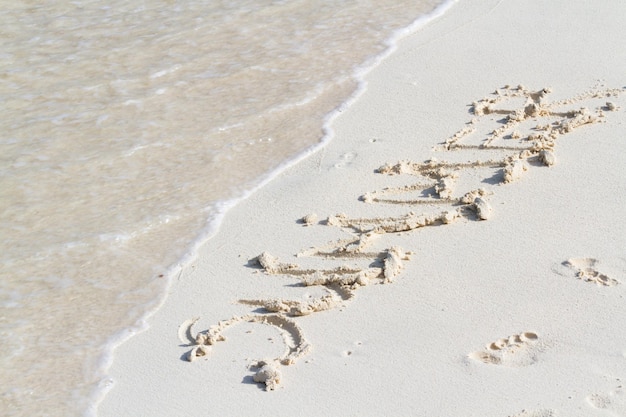 Estate scritta sulla spiaggia con l'onda.