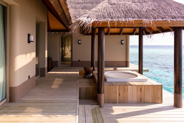 Esterno di lusso di una ricca villa sull'acqua molto costosa alle Maldive, decorata con legno naturale.
