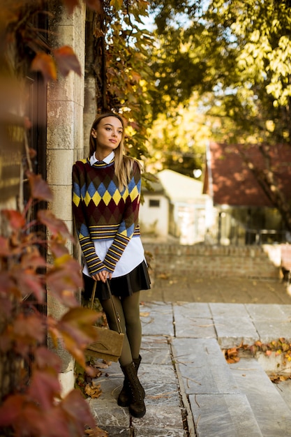 Esterno diritto della giovane donna al giorno soleggiato di autunno