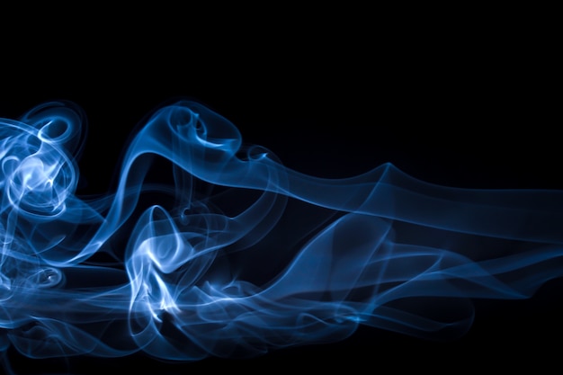Estratto blu del fumo sul nero, concetto di oscurità