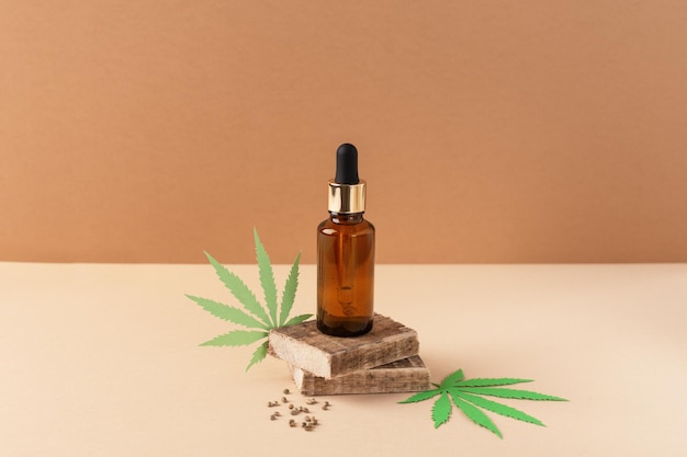 Estratto di olio di cannabis in bottiglia di goccioline su sfondo marrone Olio di cbd di marijuana medica