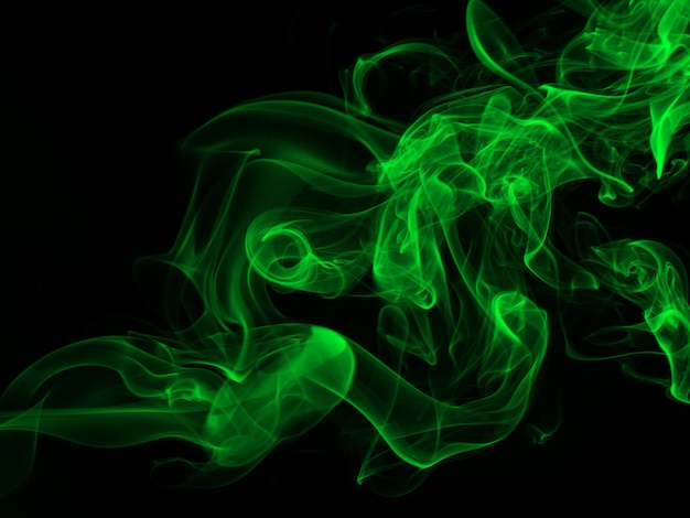 Estratto verde del fumo su backgroud nero, concetto di oscurità