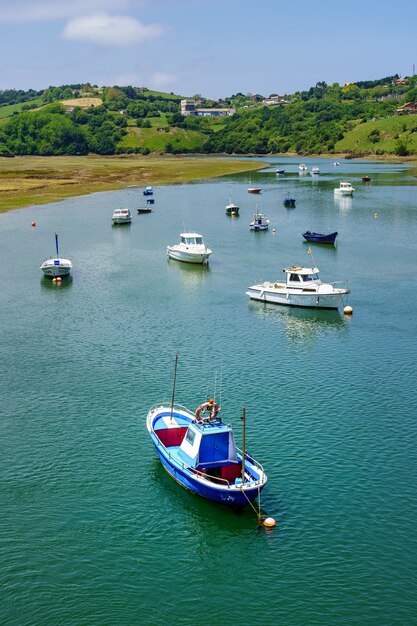 Estuario del mare con piccole barche ancorate e cielo azzurro in estate San Vicente de la Barquera