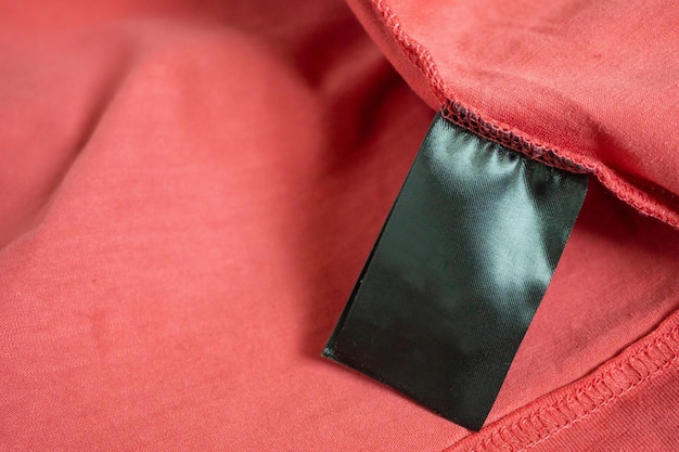 Etichetta di abbigliamento di colore nero in bianco sulla maglietta rossa