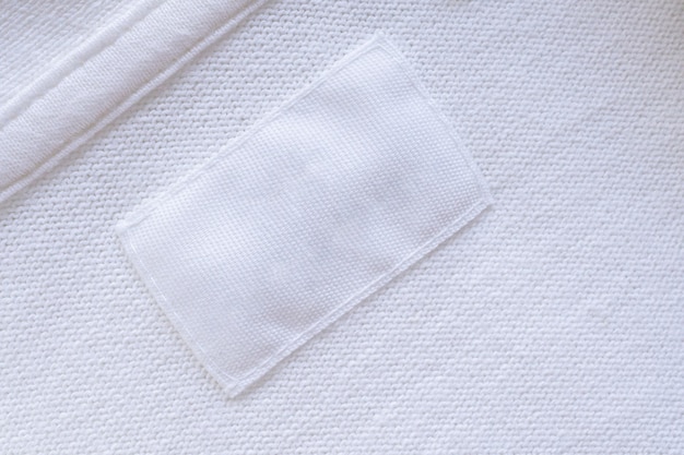 Etichetta di vestiti bianchi in bianco sul nuovo sfondo della camicia