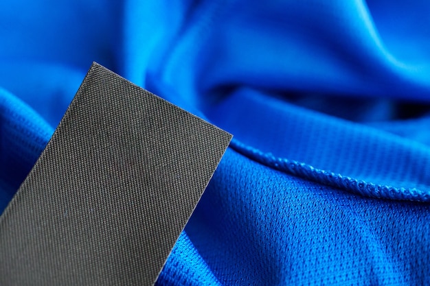 Etichetta di vestiti per la cura del bucato in bianco nero su poliestere blu