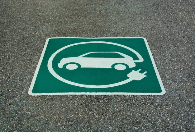 Ev stazione di ricarica per veicoli elettrici segno e segno sulla struttura dell'asfalto