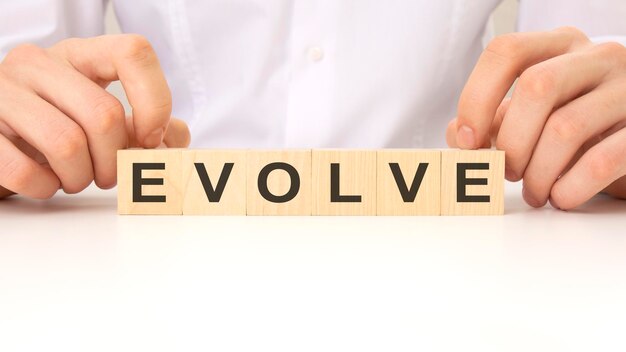 EVOLVE parola su sfondo bianco blocco di legno