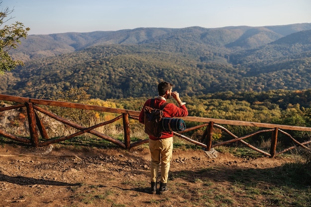 Explorer in piedi nella natura in una bella giornata di sole autunnale, mettendo gli auricolari