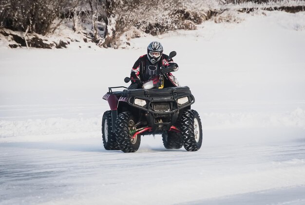 Extreme Moto rider in marcia sull'ATV in inverno nella neve. Il cumulo di neve. L'ATV ha sbandato in curva. Intrattenimento estremo invernale