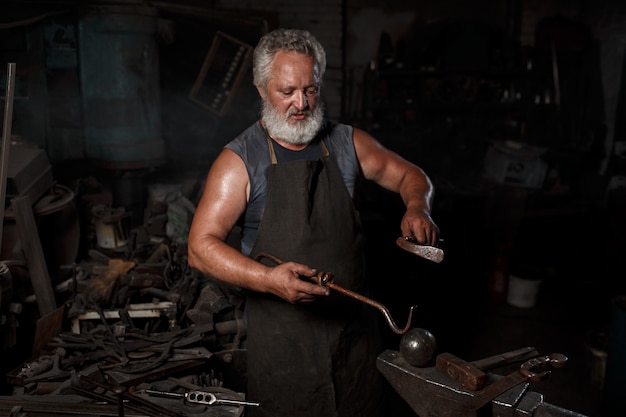 Fabbro che prepara lavorare metallo sull'incudine