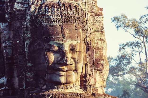 Facce di pietra dell'antica cultura Khmer tempio di Bayon nell'area di Angkor vicino a Siem Reap, Cambogia