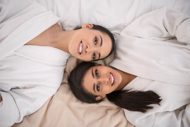 Facce felici. Gioiose belle donne positive che si trovano insieme mentre ti sorridono