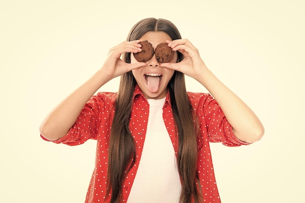 Faccia buffa Bambina con dolci da forno Ritratto di felice sorridente ragazza adolescente mangiare cookie